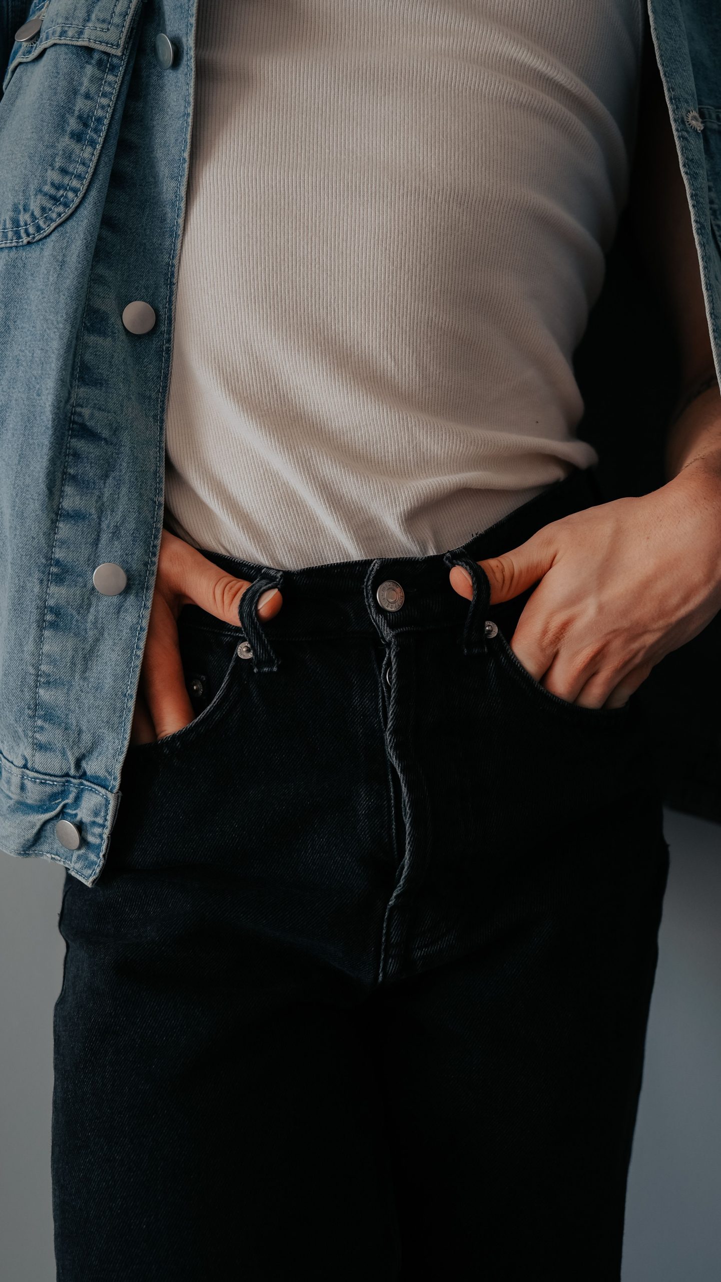 Close-up shot showcasing casual denim fashion with jeans and vest.