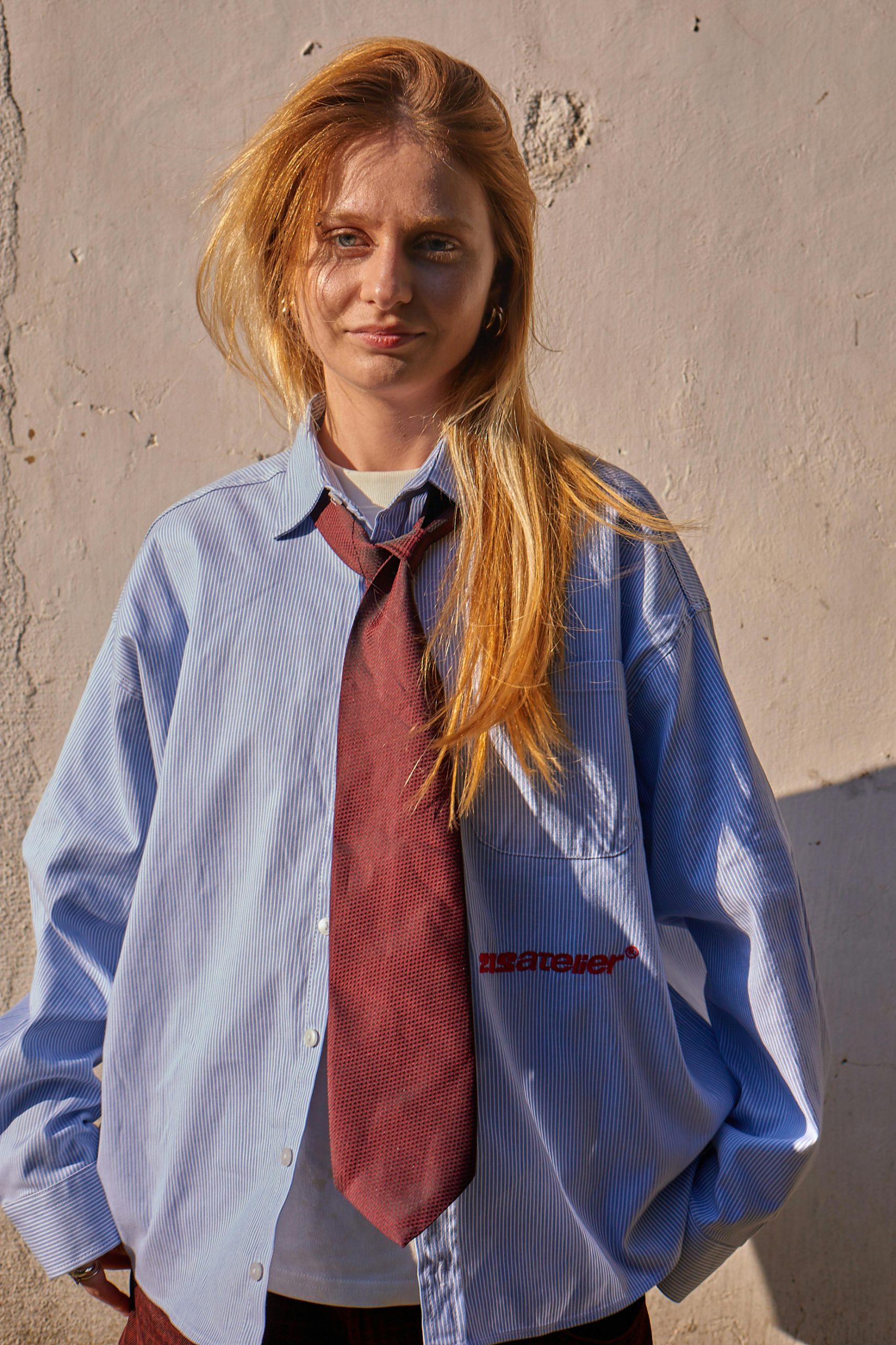 Portrait of a young woman in casual business attire under sunlight, İstanbul.